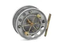 An Allcock Aerial model 7950-T9 4" centre pin reel, caged and six spoked drum with twin xylonite handles, perforated front flange (eight holes), solid rear plate and twin release/regulator forks, brass foot, rear sliding optional check button and bar spr