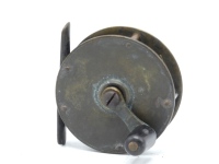 A Hardy brass 2 ½" narrow drummed crank wind trout winch, tapered horn handle on waisted straight crank winding arm with domed iron locking screw and stamped makers details, bridge foot, triple cage pillars, fixed check mechanism, light wear to patina f