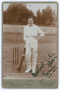 Percy George Herbert Fender. Sussex, Surrey & England 1910-1935. Sepia cabinet card photograph of Fender depicted full length in batting attire at the wickets, leaning on a bat. Cabinet card by E. Hawkins & Co, Brighton. 4.25”x6.5”. Signed in black ink wi