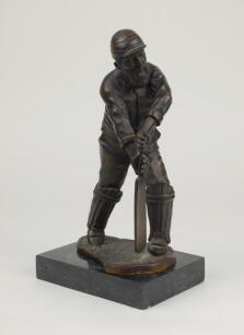 William Gilbert Grace. Gloucestershire & England. 1865-1908. Large and attractive heavy brass metal figure of Grace, full length, playing a forward defensive shot and wearing M.C.C. cap, mounted on a marble plinth. ‘W.G. Grace’ inscribed to base of figure