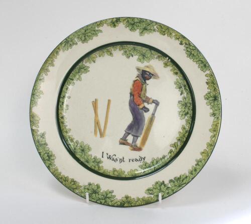 ‘I was’nt Ready’. A Royal Doulton ‘Black Boy’ bone china dinner plate, entitled ‘I was’nt ready’ printed with a boy in red shirt, yellow waistcoat and a floppy hat looking glum with his wicket broken behind him. Green floral decoration to inner and outer 