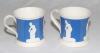 Cricket mugs. A pair of Staffordshire blue ground waisted mugs with strap handle and beaded rim. With three relief moulded figures of a batsman, bowler and wicket keeper in white, believed to be Lillywhite, Pilch and Box. c1860. Rare. Odd marks otherwise 