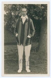 Alfred Herbert Harold Gilligan. Sussex & England 1919-1931. Sepia real photograph postcard of Gilligan standing full length wearing cricket attire and striped blazer. Signed in ink to the photograph by Gilligan. Official stamps to verso for Nias of Bright