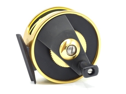 A Fenwick World Class 6 anti-reverse saltwater fly reel, gold/black anodised finish, composition handle on crossbar winding arm mounted above a milled spindle tension adjuster, block foot, only very light signs of use in original leather zip case and a W