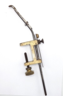 A scarce Holtzapffel fly tying vice, adjustable steel shaft with screw locking jaws, brass collar and line loop, brass "G" clamp rectangular table fitting with circular milled brass locking disc, jaw arm stamped makers details, circa 1890 (see illustratio