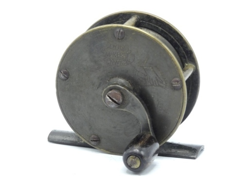 A Hardy brass 2 ¼" crank wind trout winch, domed horn handle on curved crank winding arm with domed iron locking screw, bridge foot, triple cage pillars, no check, faceplate stamped Rod in Hand trademark and enclosed oval logo, reel retains much of the or