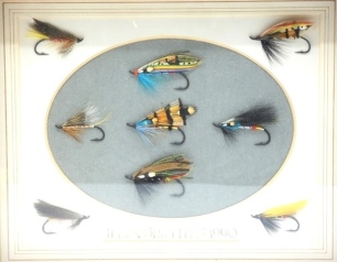 Nine fully dressed eyed salmon flies tied by Terry Griffiths, various patterns and sizes, mounted in recessed and glazed box frame, dated 1990, a framed Beauly Snow fly tied by Terry Griffiths and a framed display of four Michael Rogan pattern eyed salmo