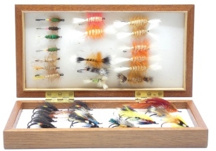 A rare collection of fifty seven Warren Duncan tied salmon flies, all tied to eyed irons, various sizes and patterns including, bombers, green machine, undertaker et al, in two boxes and sold with a collection of colour negatives of the individual flies, 