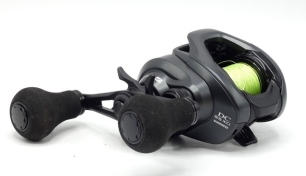 A Shimano Exsence CD SS XG bait casting reel, left hand wind model, off-set twin crank winding arm above a five point capstan star drag adjuster, light use only, in box and a Shimano "Exsence Genos B96MR" 2 piece carbon lure rod, 9'6", 8-40g, black/silve