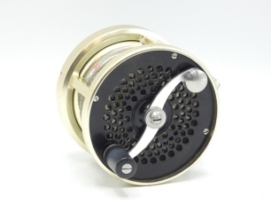 A Saracione Mk.IV 3 ½" salmon fly reel, black/gold anodised right hand wind model, counter-balanced handle on "S" scroll handle and set within an anti-foul rim, multi-perforated face and drum plate, alloy foot, rear sliding optional check button and spind