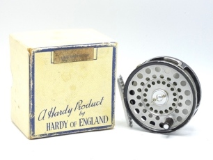 A Hardy LRH Lightweight trout fly reel and card box, composition handle, ribbed alloy foot, two screw spring drum latch, milled rim tension screw and Mk.II check mechanism, light wear from normal use, circa 1960