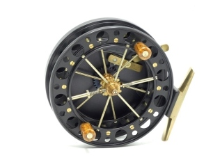 A fine Chris Lythe Scotton Long Trotter 4 ½" narrow drummed centre pin reel, black anodised finish, caged and six spoked drum with twin treen handles, double ventilated flanges and twin release/regulator forks, brass stancheon foot, rim mounted optional 