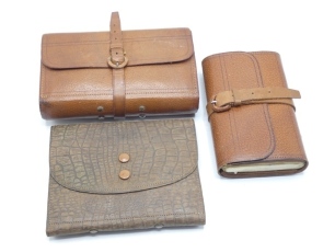 A Wheatley pigskin fly wallet, interior fitted parchment fly leaves, felt pads and end pouch cast pockets, holding a selection of thirty five fully dressed eyed salmon irons, wrap around strap, Stamped Foster Bros. retailer's details, a Hardy hide Houghto