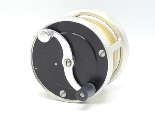 An S.E. Bogdan model 300 multiplying salmon fly reel, right hand wind model with black/champagne anodised finish, counter-balanced "S" scroll handle set within an anti-foul rim, block foot, rear milled optional check button and off-set ten point graduate