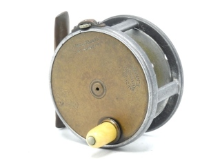 A scarce Hardy Brass Faced Houghton Dry Fly 2 5/8" wide drummed trout fly reel, domed ivorine handle, brass foot, strapped rim tension screw and early calliper spring check mechanism, slightly dished drum with four rim cusps and milled nickel silver lock