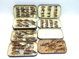 Four black japanned salmon fly boxes and salmon flies including a Malloch box with swing leaf holding 49 fully dressed gut eyed salmon flies, including some doubles, a similar box holding 61 small gut eyed salmon flies including 2 Pophams, an Army & Navy 