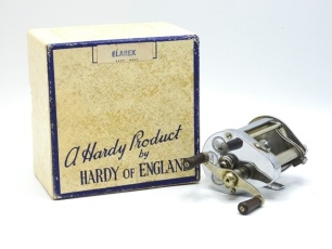 A Hardy Elarex bait casting reel and card box, chrome case, twin reverse tapered ebonite handles on crossbar winding arm, ribbed alloy foot, level line mechanism, two rear rim mounted casting controls, light use only, in original cream/blue card box, 19