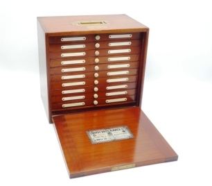 A fine Hardy Unique salmon fly reservoir, the mahogany rectangular cabinet with fall front door opening to reveal ten sliding drawers each with ivorine bun handle and twin index tabs, drawer interiors fitted bars of nickel spring metal clips with lower se