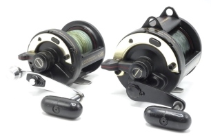 A Shimano TLD 25 multiplier reel, black finish, off-set "T" bar crank handle, rim lever drag, rear sliding optional check button, light use only, in box and a similar Shimano TLD 15 multiplier reel, boxed (2)