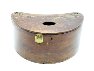 A scarce 19th Century demi-lune steamed mahogany trout fisher's creel, hinged lid with oval fish hole and off-set brass push button latch and brass lock, cream painted interior, twin brass shoulder strap brackets, 13 ½" wide, circa 1870 (see illustration