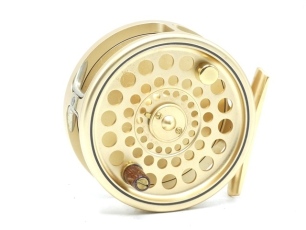 A Hardy Sovereign 7/8 trout fly reel, gold anodised finish, counter-balanced rosewood handle, two screw drum latch, rear optional check button and spindle mounted tension adjuster, ltd. ed. no. 373, new/unused condition, in leather zip case and card box