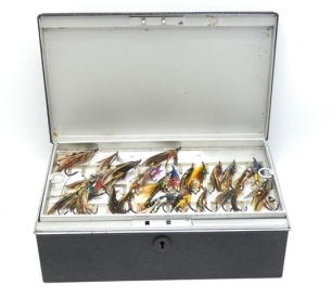 A Wheatley rectangular fly reservoir black stove enamelled finish, interior fitted five lift-out trays, each with bars of nickel silver clips and holding a selection of various salmon, sea-trout and trout flies, outer case with swing carry handle