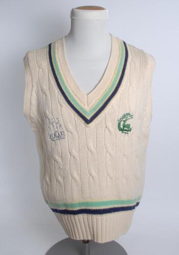 Hertfordshire white 1st XI sleeveless sweater, by ‘K.F. Knitwear’, with trimming to collar and waist in club colours, Hertfordshire emblem and sponsors logo ‘The Head Partnership’ to chest. Size 44”. Player unknown. Good condition