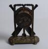 Cricket clock. A Victorian brass mantel clock. The case in the form of a set of stumps with crossed bats and ball on an oval naturalistic case base with bun feet. Dial with gilded centre. Approximately 6.5” high by 5” wide. British Union Clock Company sta - 2