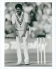 Kapil Dev Ramlal Nikhanj. Haryana, Northamptonshire & India 1975-1994. Original mono press photograph of Kapil Dev taken while bowling for India at Old Trafford 1986. Nicely signed in ink by Kapil Dev to the right edge of the image. Photograph by All-Spor