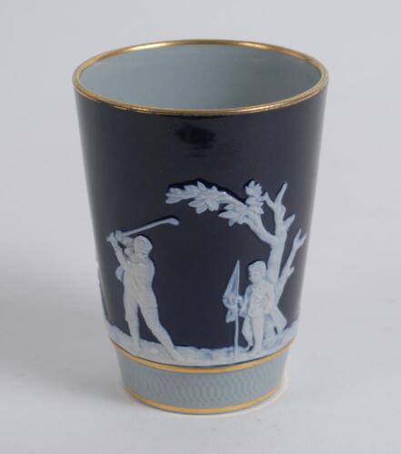 Golf beaker. An attractive Copeland Late Spode beaker, the body decorated with a continuous scene of golfers and caddies in white raised relief displaying various golfing swings and poses on a cobalt blue and grey ground with floral decoration, gilt lustr