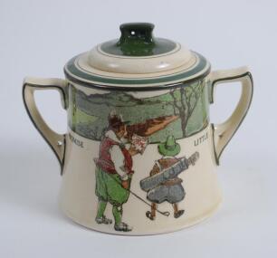 Royal Doulton ‘Golfing series’ two handled sugar basin with lid, the body decorated with a continuous scene of cavalier figures (Crombie) of golfers and caddie playing golf with proverb inscription ‘Promise little and do much’, decorated with green line d