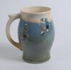 Royal Doulton Queensware blue mug/tankard with a golf scene of cavalier golfer with caddie (Charles Crombie) to one side and a smaller group playing golf to verso. Royal Doulton mark to the bottom of the mug. 5.5” tall. Circa 1930. Very good condition - 2