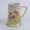 Royal Doulton tall mug with illustration by artist H.M. Bateman showing an irate golfer throwing his club and kicking his bag to one side and three other golfers laughing to the other. 5.5” tall, circa 1937. Doulton mark and number D5813 to base. Very goo