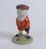 Humorous figure of a golfer with golf ball head and face. Made by Wiltshaw & Robinson, Stoke on Trent. Carlton China No.0119427. The golf ball head is attached to elastic enabling the head to move around. Signature of artist Hassall to green base. 5.25”. 