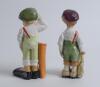 Comical Golf caddies. A pair of humorous golf caddies, each carrying a golf bag, both with enormous feet, both with glum faces. Made by Stellmacher Teplitz (Austria) Circa 1920/30’s?. Approximately 7.25” tall. Marks to base. Minor wear otherwise in good c - 2