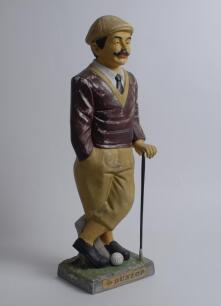 ‘Dunlop’. Large advertising Dunlop advertising figure. A colourful ceramic advertising figure of a golfer, leaning on this club on base, with the slogan on label. 21” tall. Some wear and marks to the paint work otherwise in good condition. The counter top