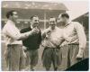 Eddie Baily, England 1951. Two original mono press photographs originally from the personal collection of Baily. One depicts Alf Ramsey, Eddie Baily, Les Medley of England and Ron Burgess of Wales meeting on the pitch, wearing football attire. Handwritten