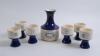 ‘Melbourne Cricket Ground. Centenary Test Match 1877-1977’. Full set of ceramic carafe and six wine goblets in blue and cream glaze, produced by the Elischer factory to commemorate the Centenary Test. The carafe with ‘Melbourne Cricket Ground’ motifs of t