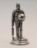 William Gilbert Grace. Gloucestershire & England. Large and impressive silver plated full length figure of Grace wearing cap and pads and carrying a bat to right hand, his left hand is holding a very large cricket ball with a circular hole to the top whic