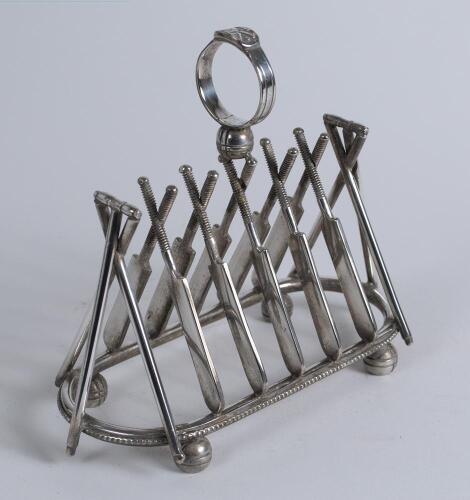 Cricket toast rack c1900. A Victorian silver plated, six division toast rack with five pairs of crossed cricket bats, with a set of angled cricket stumps and bails at each end, the handle of the rack in the form of a cricketer&rsquo;s belt and buckle on a crick