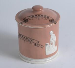 &lsquo;Box and Pilch&rsquo;. A Victorian tobacco jar and lid, applied with raised figures of Thomas Box and Fuller Pilch in white, on a light puce ground with title &lsquo;Tobacco&rsquo; and floral decoration to sides and lid. The jar with lid stands approximately 5&rdquo; tall. Good/