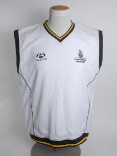 Cornwall white 1st XI sleeveless fleece overtop/sweater with trimming to collar, waist and cuffs in county colours, Cornwall emblem and sponsors logo &lsquo;agame&rsquo; to chest. Size &lsquo;Large&rsquo;. Player unknown. Good condition