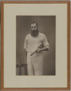 William Gilbert Grace. Large impressive sepia photograph of Grace, three quarter length, wearing cricket whites and holding a cricket bat under his arm. The photograph mounted, framed and glazed and overall 11&rdquo;x14&rdquo;. W&S Ltd. Barraud of Oxford Street, Lond
