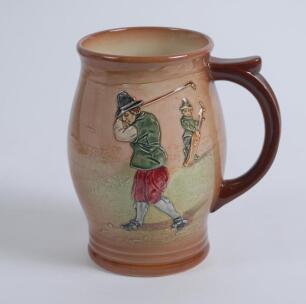 Royal Doulton &lsquo;Airbrush Brown&rsquo; Kingsware mug/tankard with a golf scene of cavalier golfer with caddie (Charles Crombie) to one side and a smaller group playing golf to verso. Royal Doulton mark and No. 5716 to the bottom of the mug. 5.5&rdquo; tall. Circa 1930