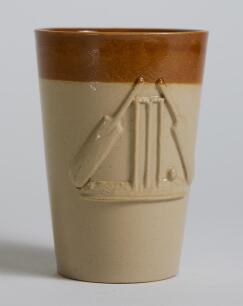 Cricket cup/beaker. Attractive early Victorian Staffordshire cup/beaker moulded in relief with a set of cricket stumps with bails, two bats and a cricket ball. 4.5&rdquo; tall, the letter &lsquo;J&rsquo; impressed to base. Good condition