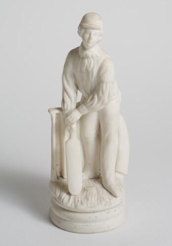 Continental &lsquo;parianware&rsquo; style cricketing figure. Excellent figure of a moulded white porcelain batsman wearing a cap, standing in front of the wicket with bat in hands, blazer hanging on the tree, gloves at his feet behind him on circular base. Appears T