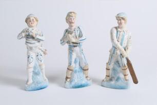 Continental coloured porcelain figures of batsman. A pair of batsman wearing blue and white striped clothing and blue caps. Both numbered 47 to inside of base. Lacking their wooden bats. Gold lustre decoration. Sold with a Sold with a similar figures, aga