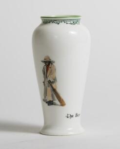 &lsquo;The Boss&rsquo; Royal Doulton Black Boy miniature vase, entitled &lsquo;The Boss&rsquo; printed with a boy in red shirt and a floppy hat, wearing an umpires&rsquo;s coat and holding a bat to one side and to the other, a crest with &lsquo;The All Black Team&rsquo;. Green floral decoration t