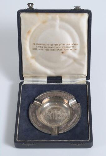 England v Australia 1861-1961&rsquo;. Hallmarked silver ashtray with England and Australian emblems to centre and wording England v Australia 1861-1961&rsquo; to borders. In original presentation box which has titles to lid. G