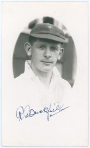 Richard George &lsquo;Dick&rsquo; Duckfield. Glamorgan 1930-1938. Mono real photograph postcard of Duckfield in cameo, head and shoulders wearing cricket attire and Glamorgan cap. Nicely signed in blue ink to the lower border by Duckfield. Official stamp to verso for